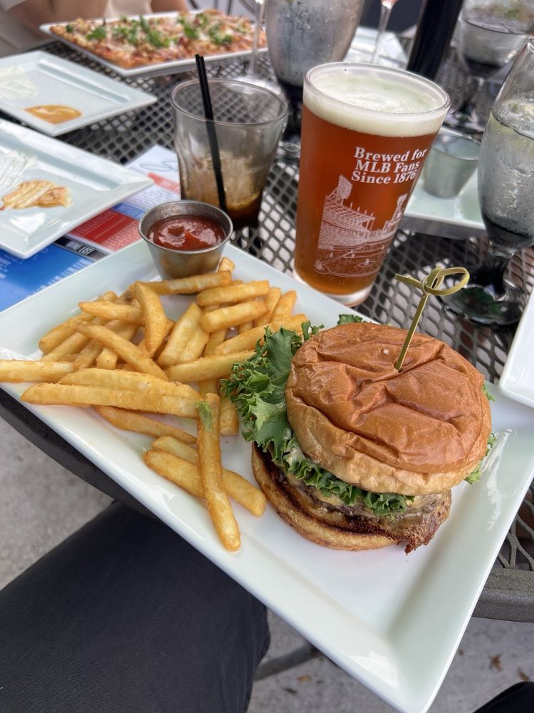 Classic burger with fries and a craft beer on the patio